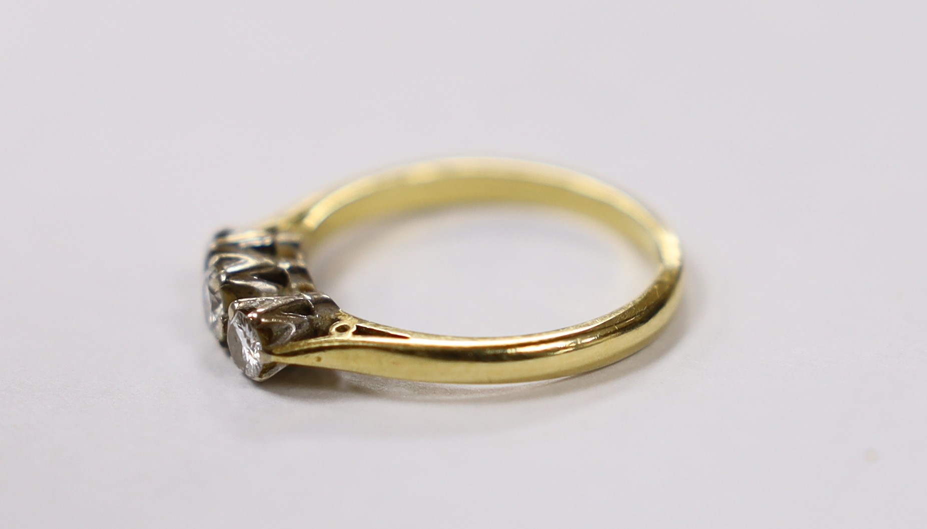 A modern 18ct white gold and three stone diamond set ring, size P, gross weight 3.9 grams.
